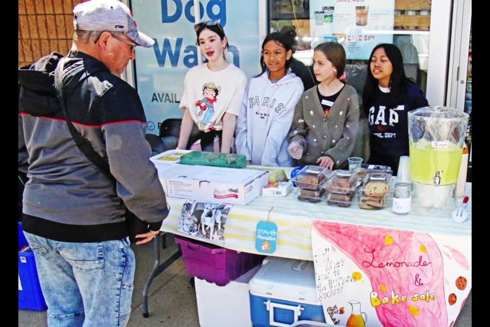 Students from St. Michael School had a baking and lemonade stand, as part of Pet Valu's 10th anniversary event which included a petting zoo. The girls are, from left, Heidi, Izanna, Ava and Cielo. They are raising money for the Weyburn Humane Society as part of an "acts of kindness" school project.
