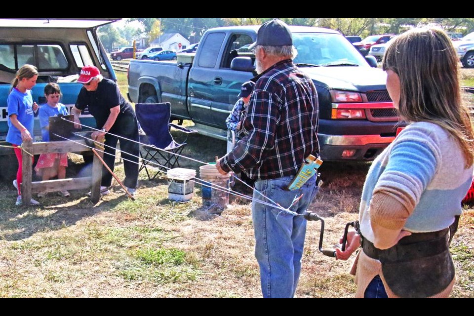 Ann Jensen, at right, anchored the rope-making as her daughter Lydia and niece Brady Nielsen were at the far end, at Radville's Heritage Day on Saturday.