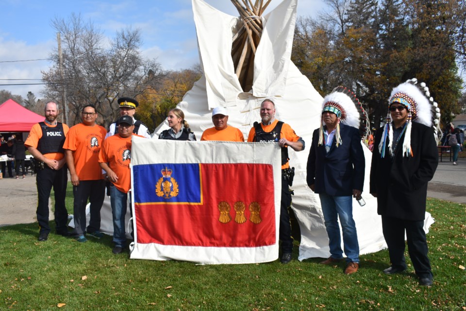 After the teepee was finished, from left, SGT. Jeff Stringfellow, Denby Shingoose, (behind) Chief Superintendent Tyler Bates, Bryan Shingoose, Sgt. Meagan Stringfellow, Cody Cadotte, Cst. Debore, Chief Clinton Key of The Key First Nation, and Chief Lee Kitchemonia of Keeseekoose First Nation stood by the RCMP flag.