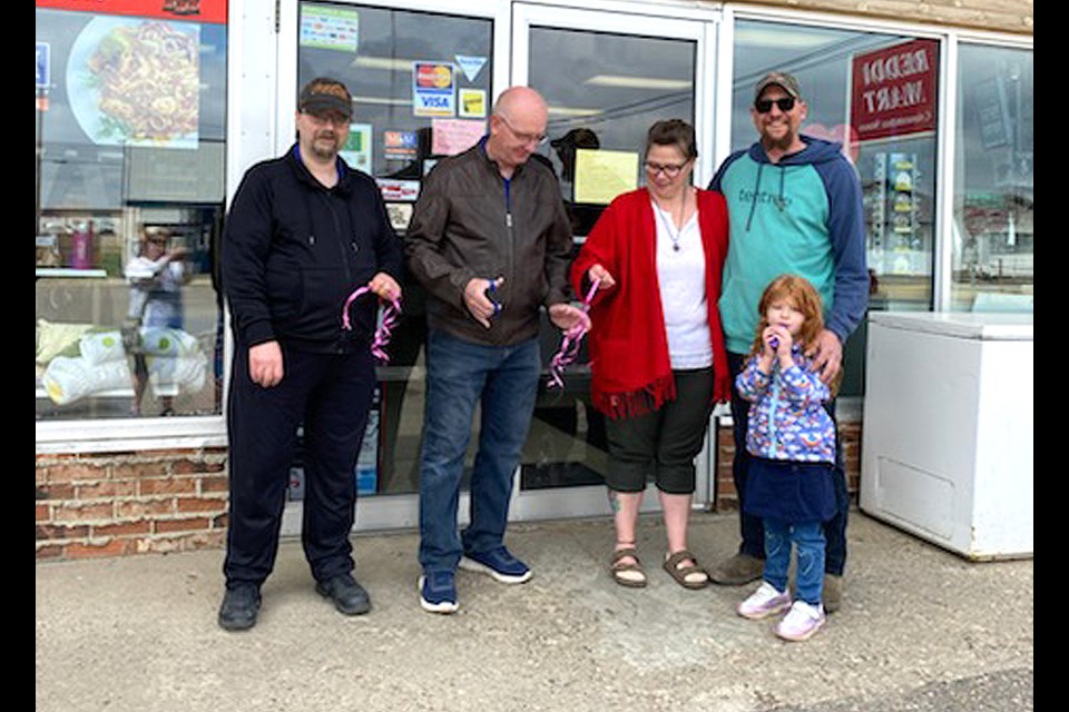 Reddi Mart’s new owner, Jerel Wood stands with Wilkie Mayor, David Ziegler, and co-owners Lauralee and Kevin Kropf and their granddaughter Sky-Ra at the May 28 grand opening event.