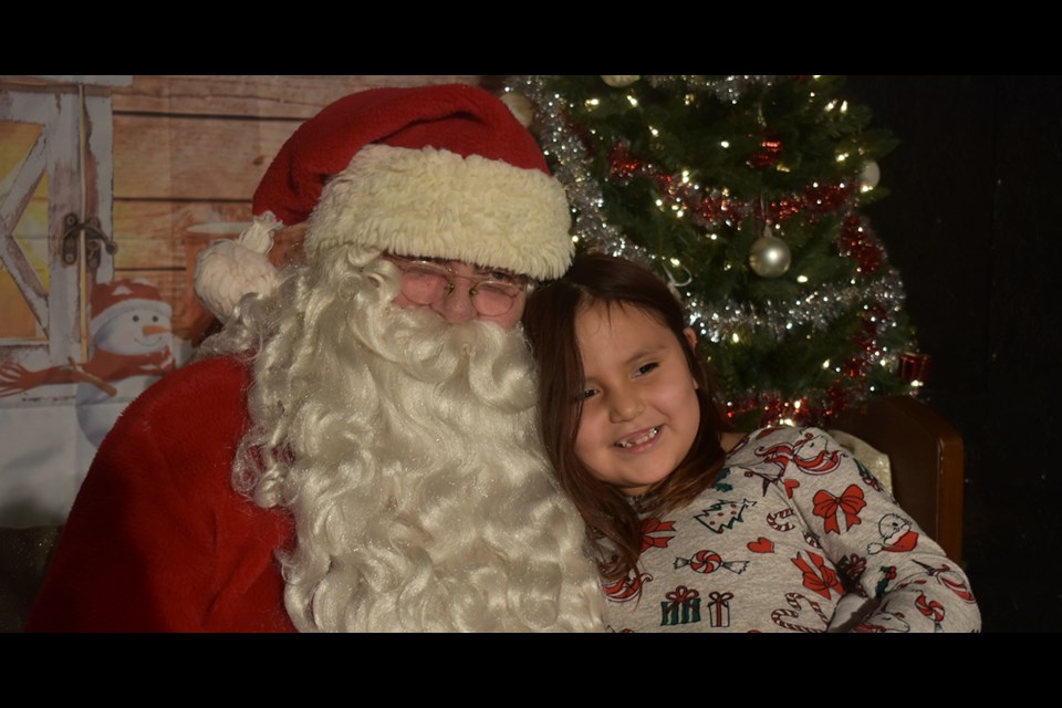 Elisa Kakakaway of Cote First Nation was among the children to greet Santa Claus when he visited Kamsack during the Community Christmas Concert at the Playhouse theatre on Dec. 18.