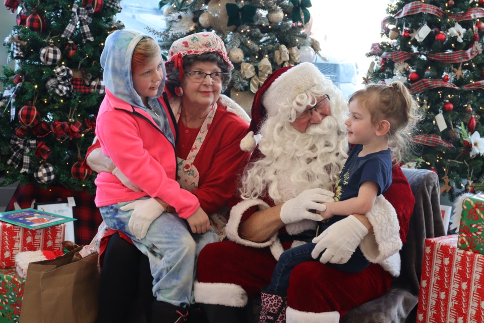 Caroline and Darcy tell Santa and Ms Claus their Christmas lists.