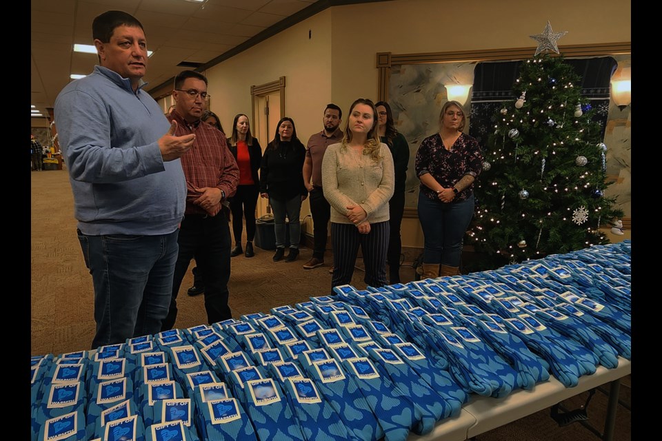 Saskatoon Tribal Council Chief Mark Arcand, left, introduces McKercher LLP Executive Committee Chair Collin Hirschfeld after receiving a donation of 300 socks.