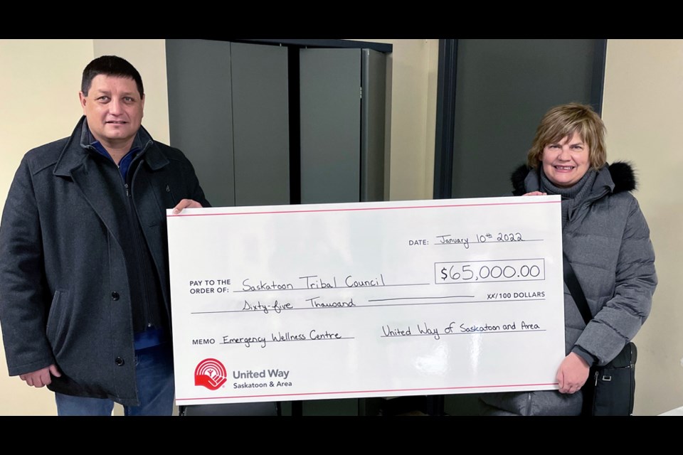United Way-Saskatoon Chief Executive Officer Sheri Benson, right, hands the ceremonial cheque to Saskatoon Tribal Council Chief Mark Arcand.
