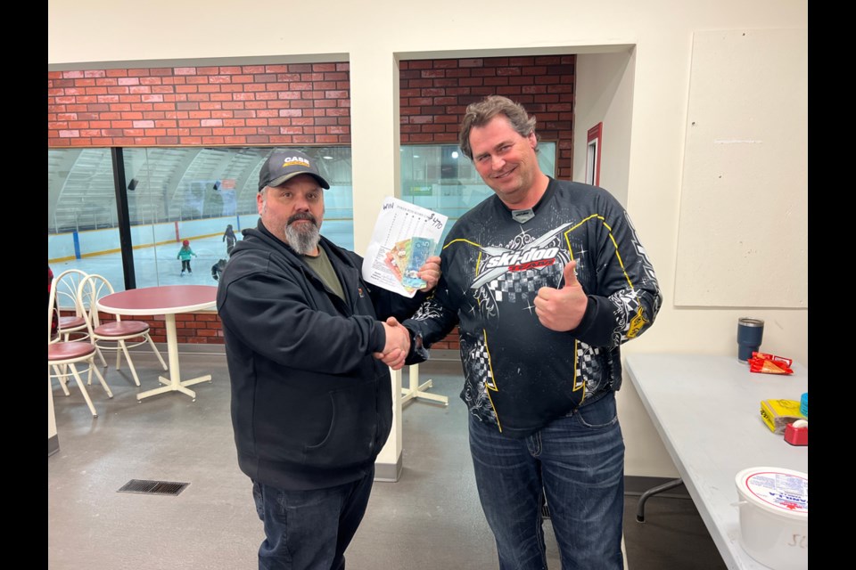 From left, Stoughton recreation director Steve Massel presents Scott Ogilvie with his winning hand prize money. Photo by Stephanie Zoer