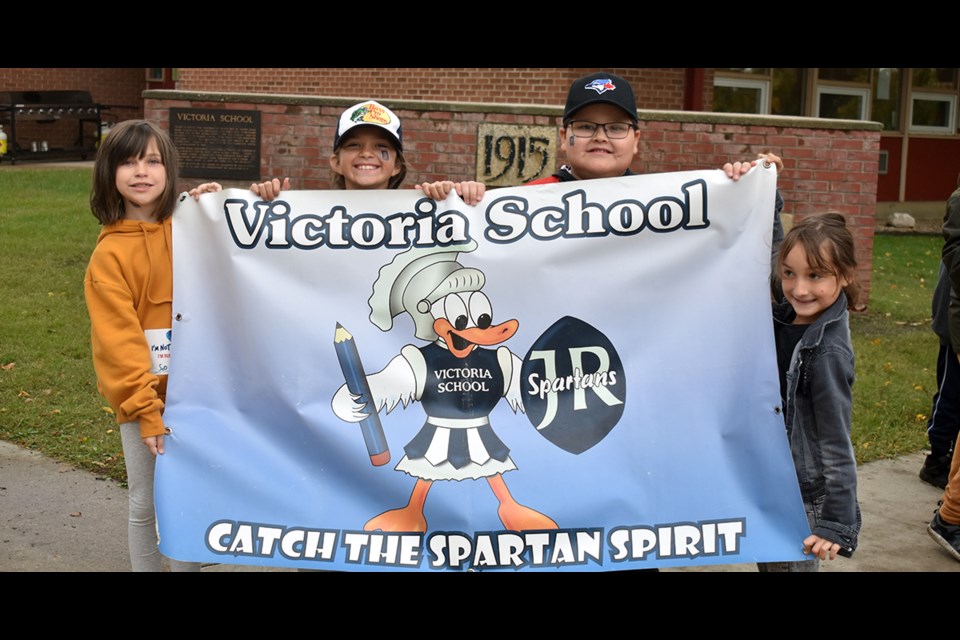 Leading the Victoria School’s Terry Fox parade on Friday carrying the school’s Junior Spartans banner, from left, were: Quinnley Erhardt, Anna Reilkoff, Lucas Stevenson and Mackendra Lucas.