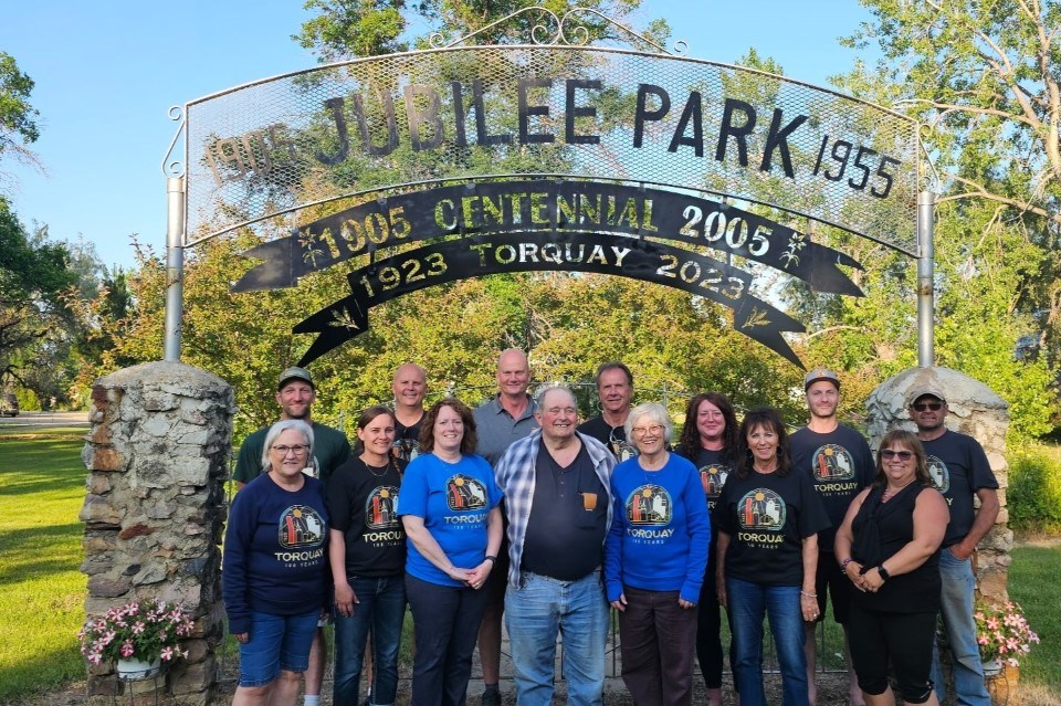 The organizing committee gathered for a group photo beneath a new sign in the park. 