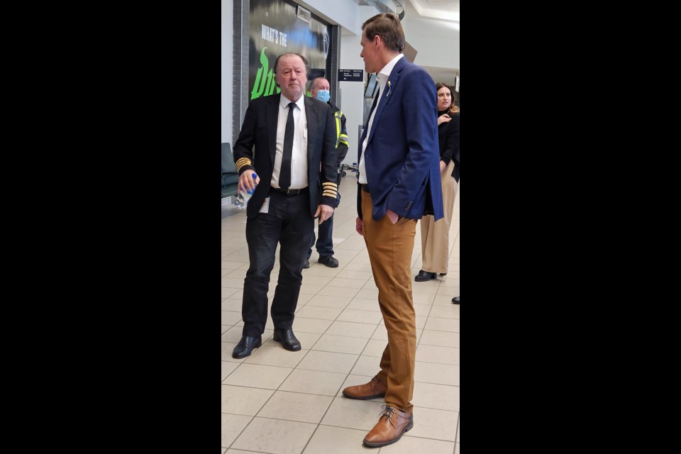 Saskatoon Mayor Charlie Clark, right, talks with Captain Enrique Piñeyro, who flew the plane that brought 200 Ukrainian refugees to Saskatoon on Wednesday night, Nov. 23, at the Saskatoon John Diefenbaker International Airport. 