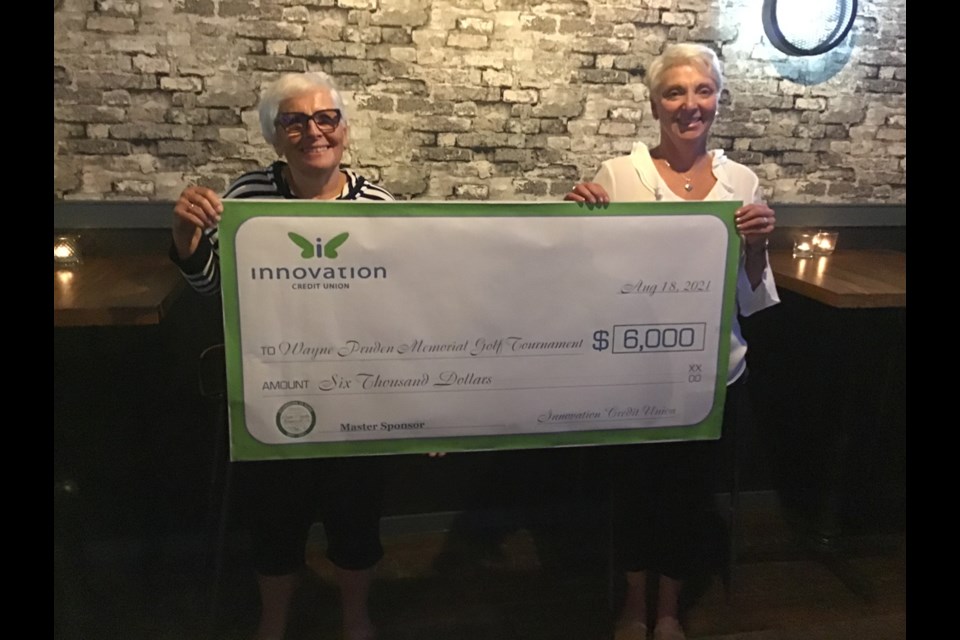Sue Pruden-McIvor and Rosalie Payne hold a cheque for $6,000 from Innovation Credit Union to sponsor the Wayne Pruden Memorial Golf Tournament.