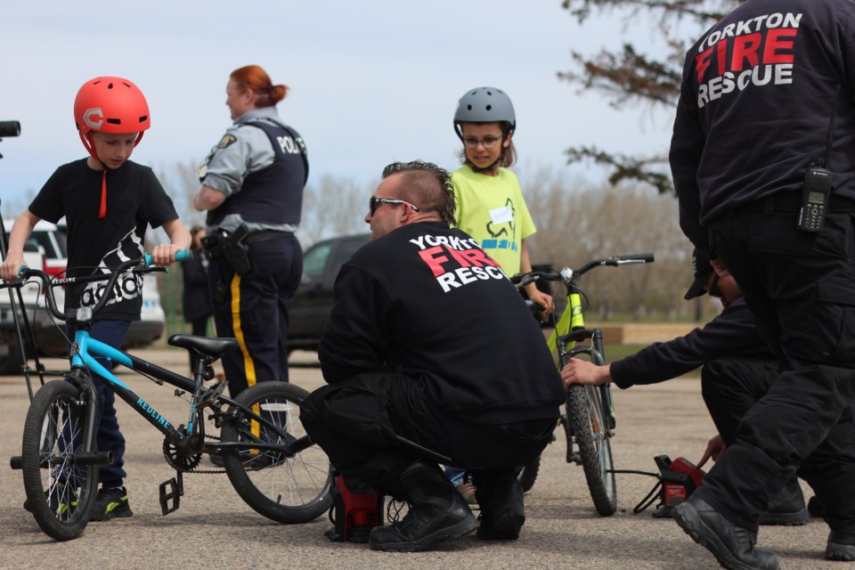 A member of the Yorkton Fire Department checks the air pressure on a students bicycle tire.