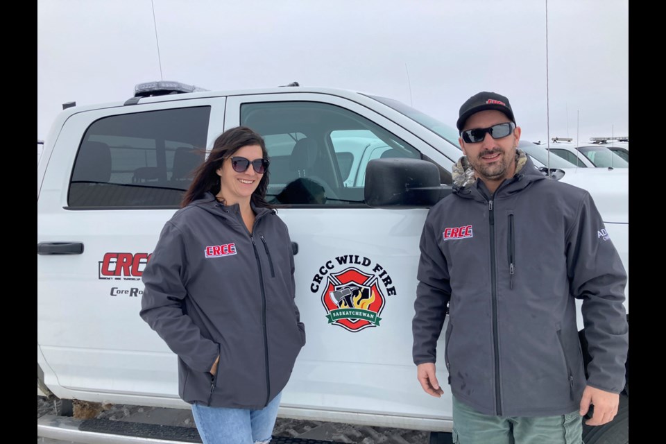 Adam Hartle, right, and his wife pose beside one of the trucks used by CRCC Wildfire Division in assisting firefighters in times of wildfire.