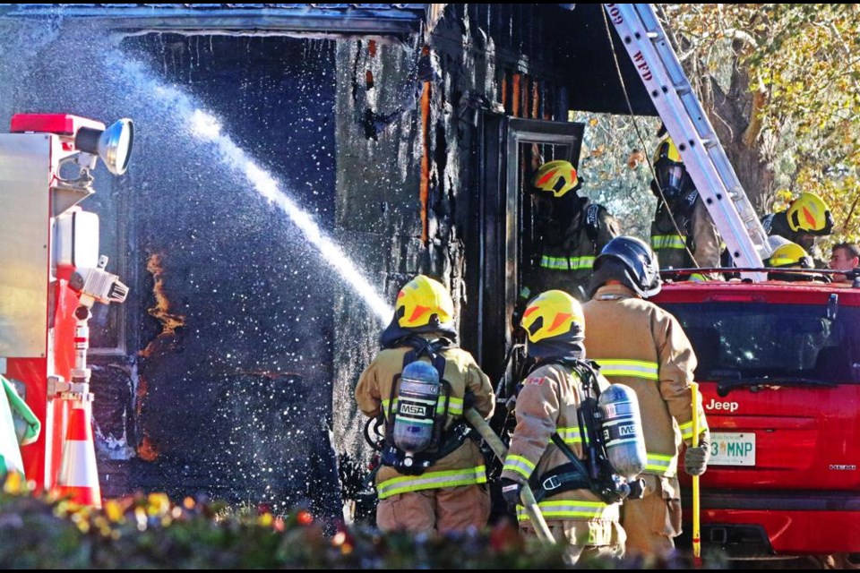 Fire crews poured water on smoldering remains of a fire in this home on Mitchell Crescent on Tuesday morning.