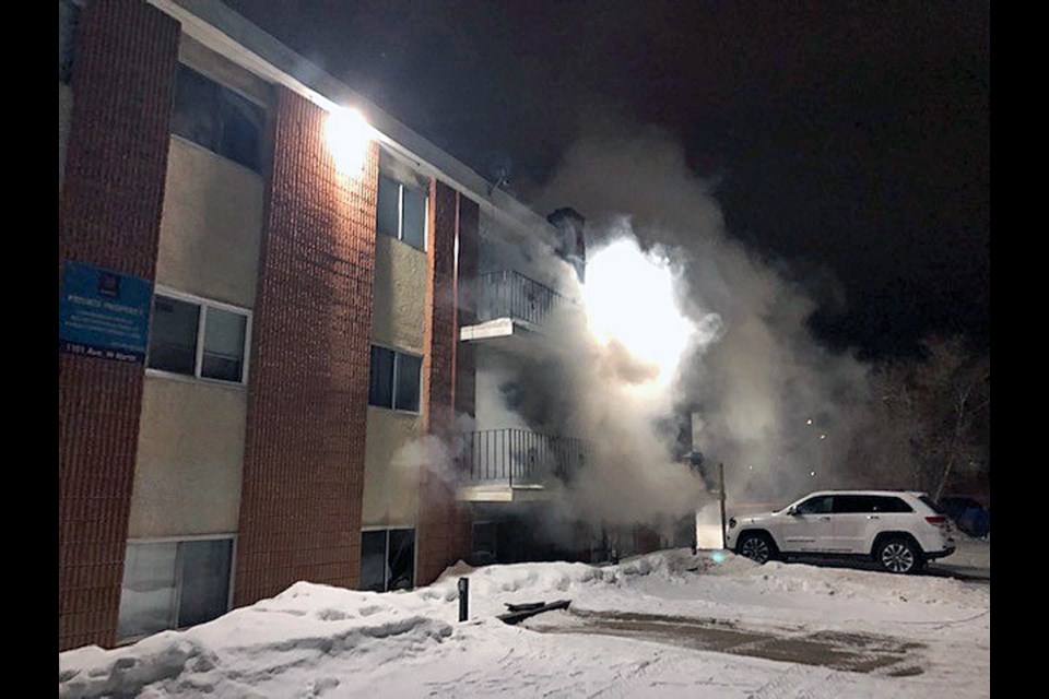 Smoke is seen coming out of a basement suite in the apartment complex in the 1100 block of Avenue W North.