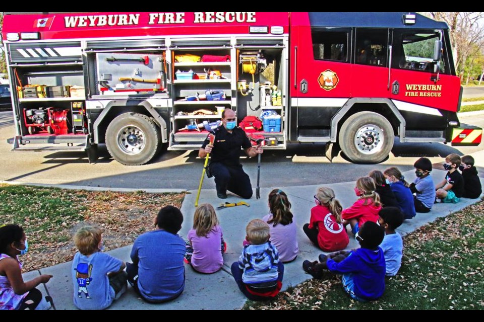 Weyburn career firefighter Marc Schweitzer explained what some of the various tools and gadgets are on a fire truck, during a visit with the Grade 1 class at St. Michael School on Wednesday during Fire Prevention Week.