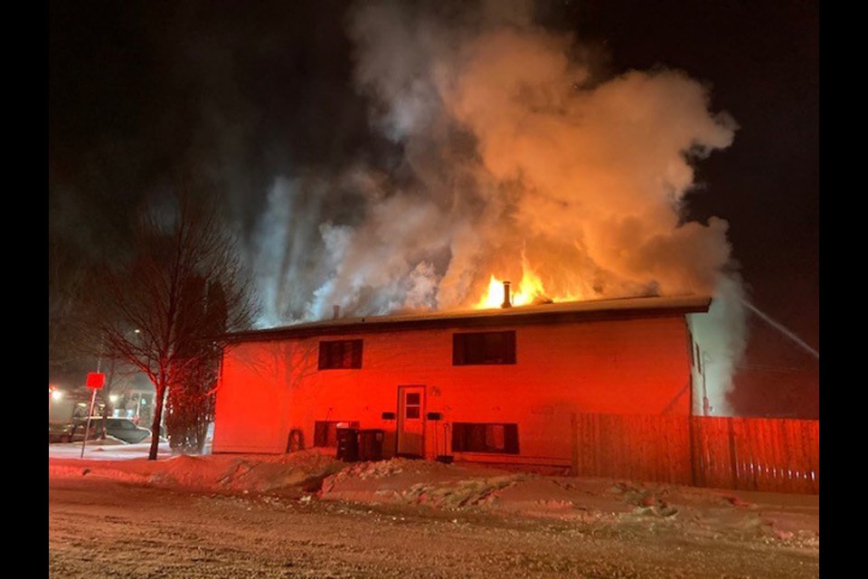 Flames and smoke emerge from the structure's roof in a Sunday fire in the 300 block of 109th Street West.