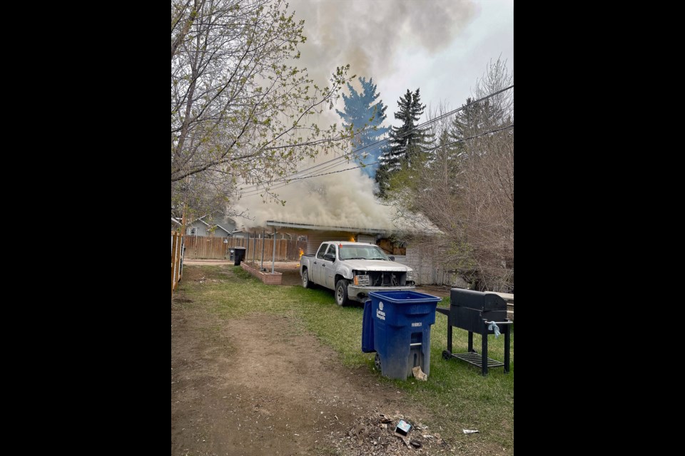 A plume of smoke rises as fire engulfs a structure on Avenue B North.