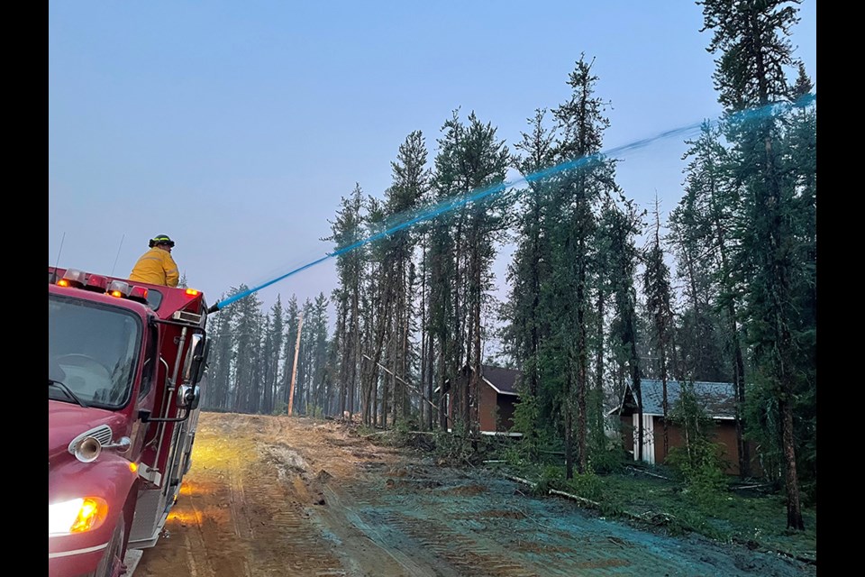 From the back of the fire truck, Will Dupperon applied fire resistant gel to structures, trees and grounds. 