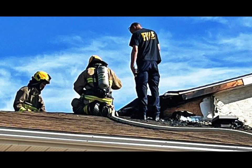 Fire fighters work on putting out the fire in the roof-attic area of the Weyburn Free Methodist Church on Saturday morning.