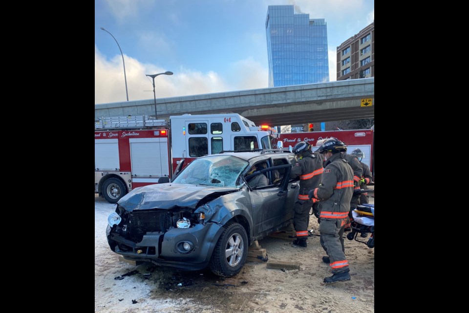 Fire crews work to pry open the car door to help an individual inside one of the cars involved in a vehicle collision Monday.