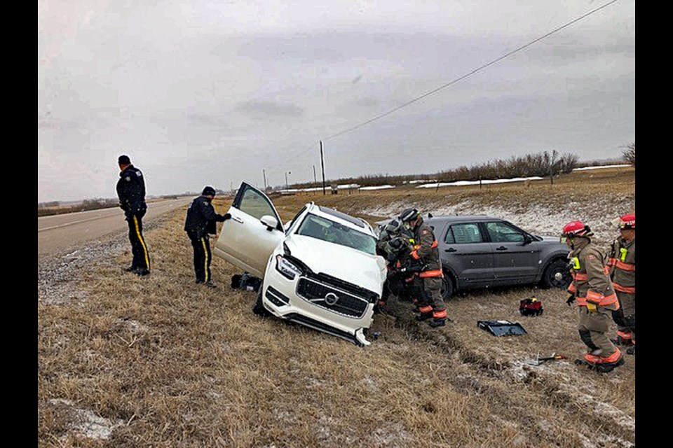 Saskatoon Fire Department and Asquith Fire Department crews work together to extract the patient out of the SUV.