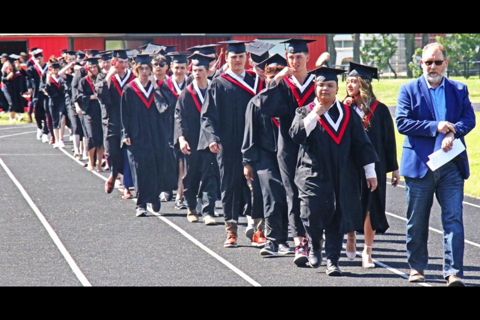 Teacher Darren Abel led the Class of 2023 onto the track behind the bleachers, to be in place for entering the area set up for Grad ceremonies at Darold Kot Field on Saturday morning.