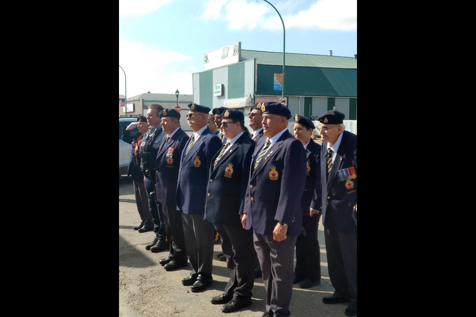 Legion members in Unity watch as the Canadian flag is raised on the new flag pole.