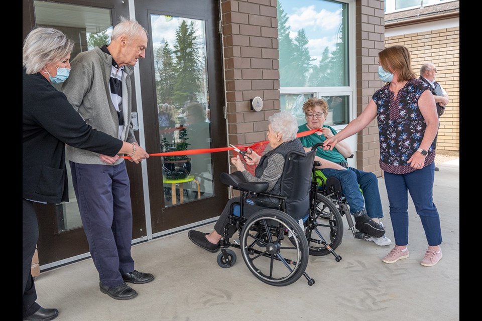 A Villa Pascal resident cuts the ribbon to officially open the new wing.