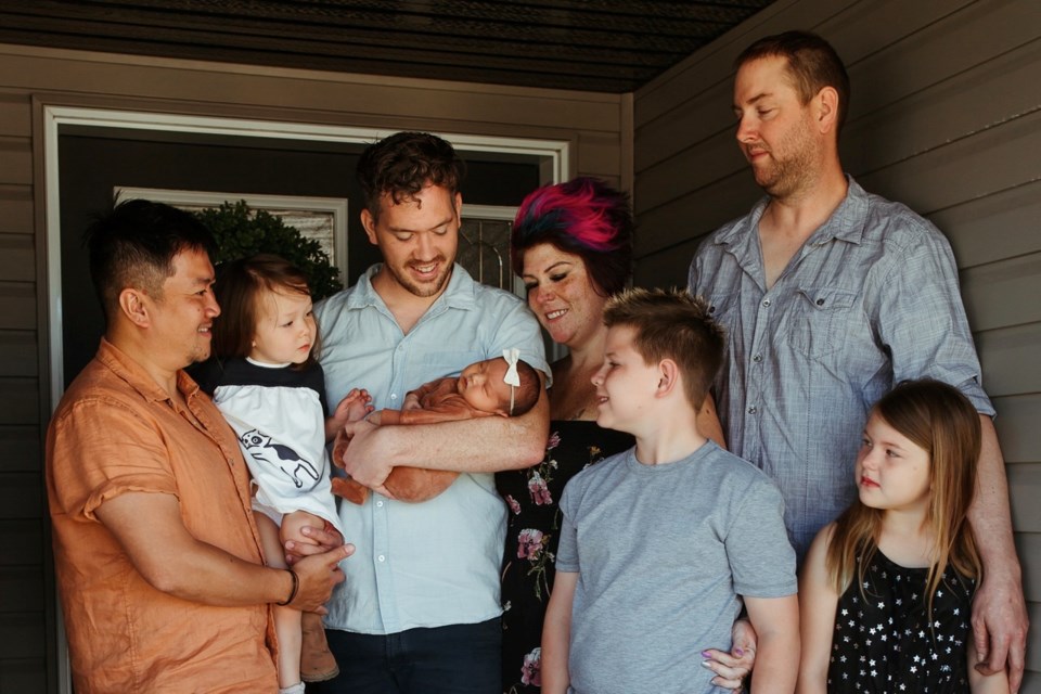 A big family welcomed baby Josephine into this world. From left, Chewn Bangsund, Florence Pham Bangsund, Tim Bangsund (holding Josephine), surrogate mother Melissa Mosley and her family, Travis, Huxton and Oaklyn Mosley. 