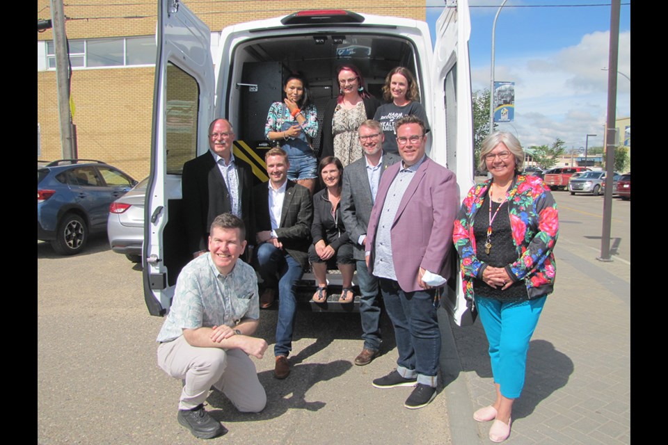 The North Battleford area is now home to Saskatchewan's fourth mobile harm reduction van that will transport safer supplies to the community to save lives and help reduce the spread of sexually transmitted and blood-borne infections. At the official launch were: kneeling, Johann Engelke ,Director Primary Care-SHA; middle row, Ryan Domotor, MLA, Cut Knife-Turtleford; Jeremy Cockrill, MLA Battlefords, Minister of Highways; Amanda Maunula, outreach worker with Battlefords Family Health Centre; Everett Hindley, Minister of Mental Health and Addictions; Kent Lindgren, director of the Battlefords Family Health Centre and City of North Battleford councillor; Patricia Whitecalf Ironstand, executive director of BRT6HC, in the van, Leanne Thomas, peer outreach worker; Cymric Leask, HIV Project Co-ordinator, BFHC; Danielle Radchenko, Sexual Health Co-ordinator, SHA.