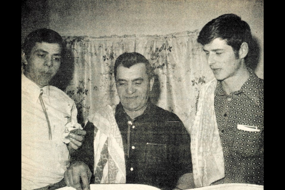 Jim Stabbler, left, tastes the meat served by the Reward Elks Club at a beef supper held in the Reward Hall. Standing by Stabbler are Zack Boser and Norbert Herle. 