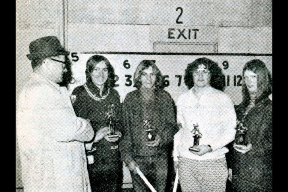 Receiving curling trophies from E. Thiessen are skip Harold Greenwald, third Brennan Merkosky, second Pat Risling and lead Chris Martin. The foursome won an event at the 1973 UCHS annual bonspiel. 