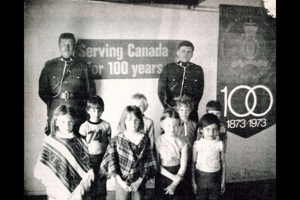 Csts. Jack Skrein and Al MacIntyre gave Norman Carter School Grade 1 and 2 pupils a tour of the detachment office, as part of an open house in recognition of the RCMP’s 100th anniversary. (Wilkie Press archives)
