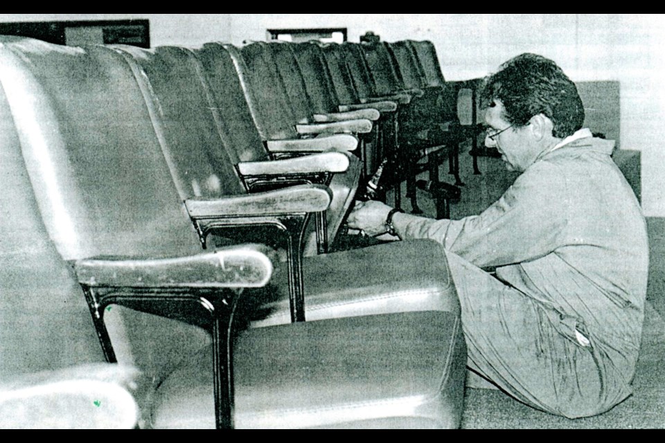 Brian Miller of the Wilkie Kinsmen, one of several volunteers installing theatre seats in the community centre skating rink lobby in 2002. (Photo Wilkie Press archives)