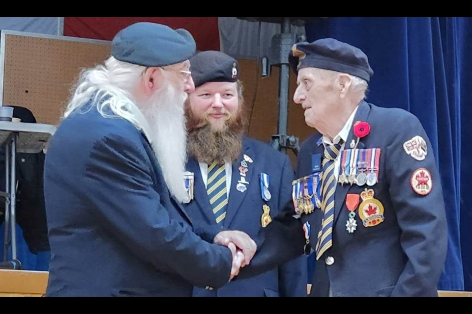 Jim Spenst, right, receives congratulations from Jim (Frosty) Forrest, president of the Estevan legion branch, while Troy LeBlanc looks on.