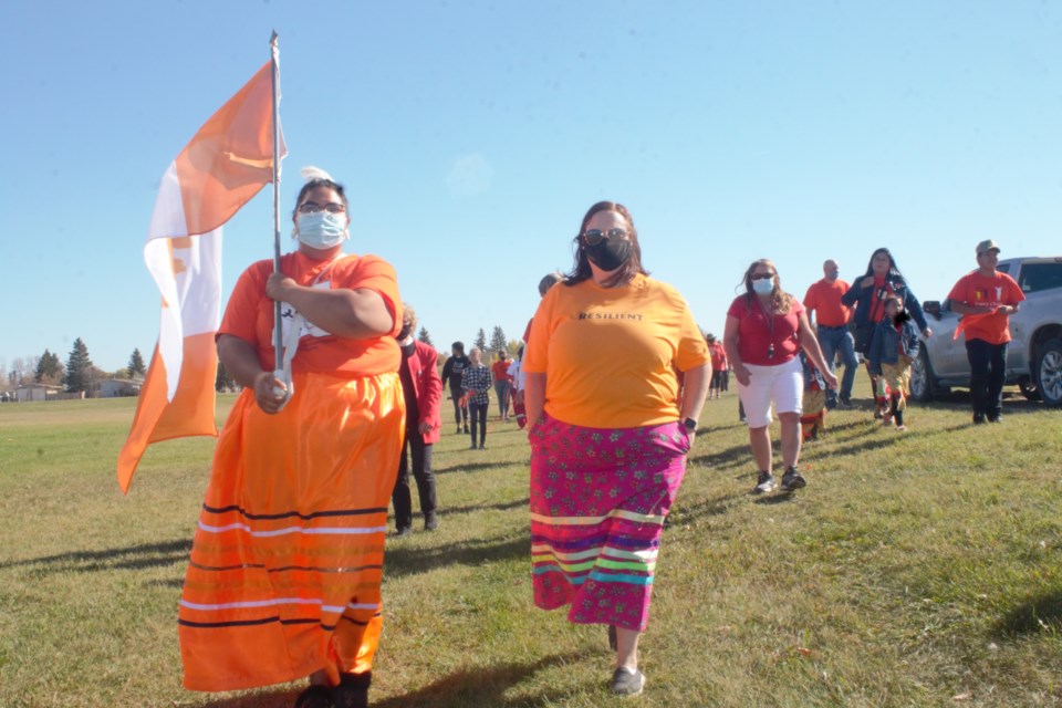 Community members head toward Melfort City Hall to raise the flag designed by Kinistin resident, Tara Aisaican.