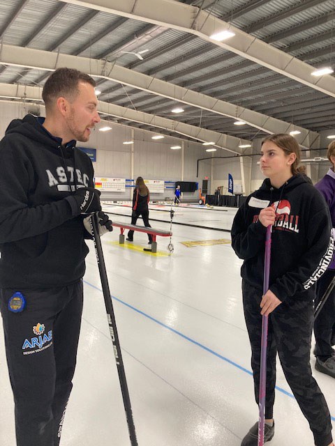 UCHS Grade 10 student Jordis Zunti listens talks to skip Brendan Bottcher during the first annual Astec Safety Inc. Team Bottcher Junior Clinic.