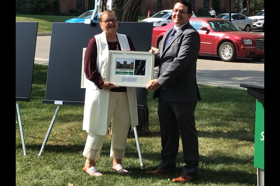 Minister Laura Ross presents Jesse Hopkins, son of John Hopkins, with a presentation the commemorative plaques.