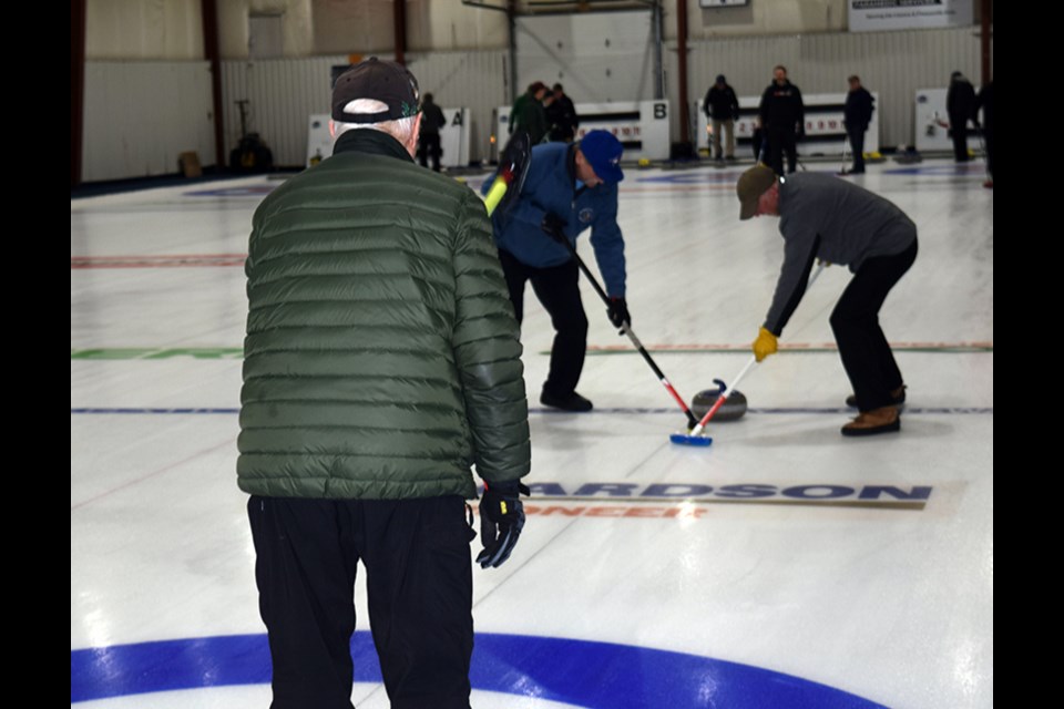 From left, while Peter Wiwchar called the line, Vern Schick and Rory MacDonald really leaned on their brooms to keep this rock headed in the right direction. 