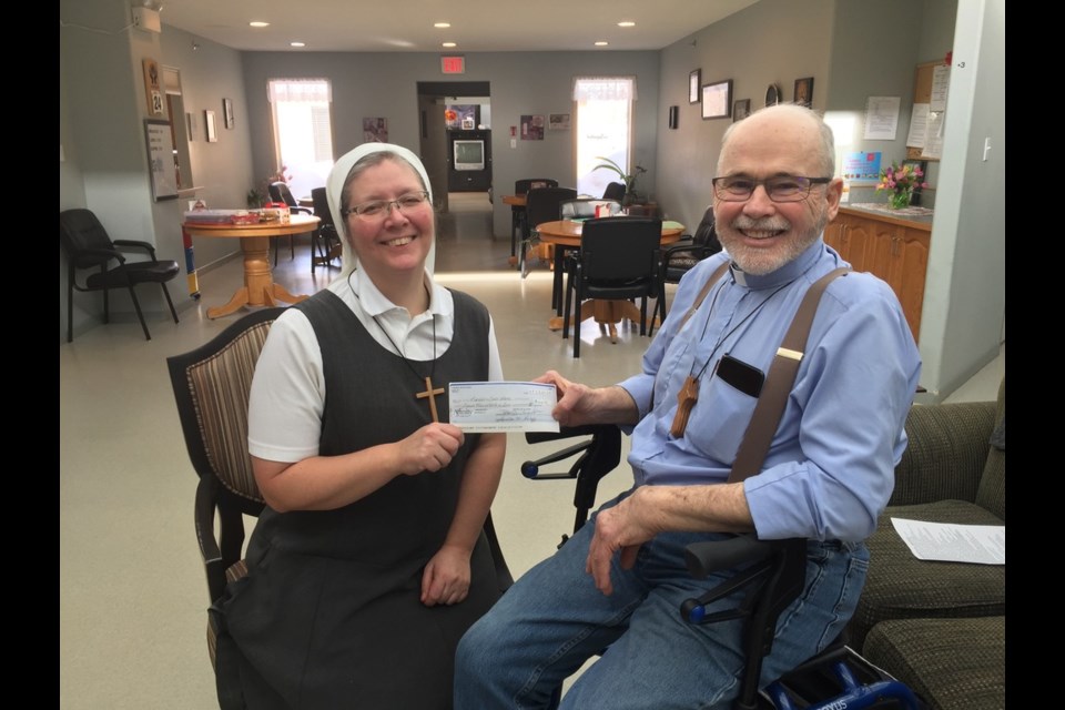 Proceeds of $410 from a St. John’s Anglican Church Shrove Tuesday pancake supper are presented to Sister Peter by Rev. Sheldon Carr. 