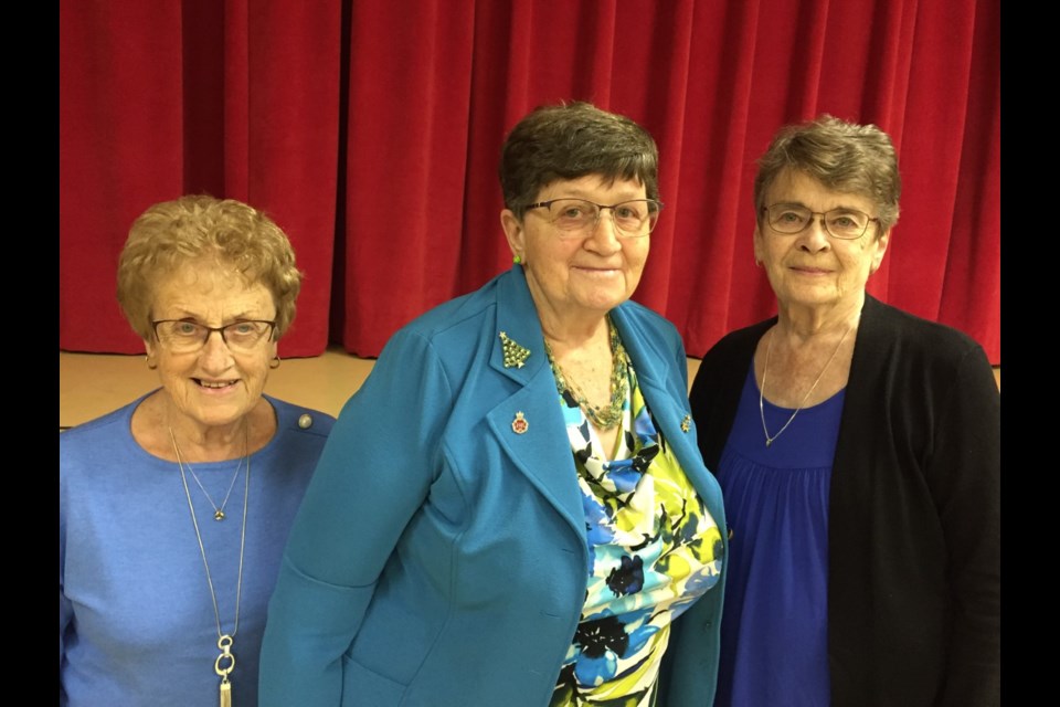 Dianne Rawlyk, and Florence Neufeld pin the Queen Elizabeth II Platinum Jubilee pin on Lorraine Olinyk (centre). 