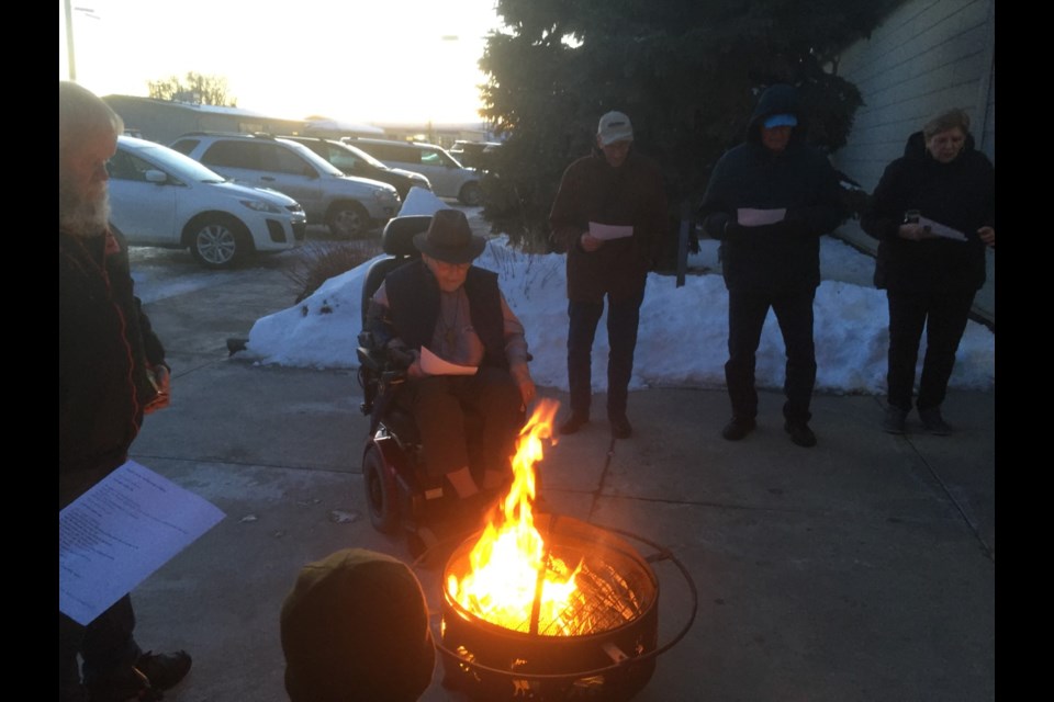 Rev. Carr and patrons lighting the palm leaves and reading a short prayer for the burning of palms Feb. 13. 