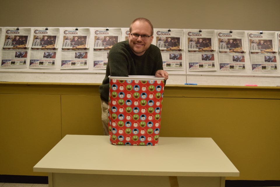 Devan Tasa, the publisher of The Canora Courier, draws the winners from the Courier's shop local contests. The winners were Kathie Gerrard of Canora and Jennifer Choboter of Buchanan.