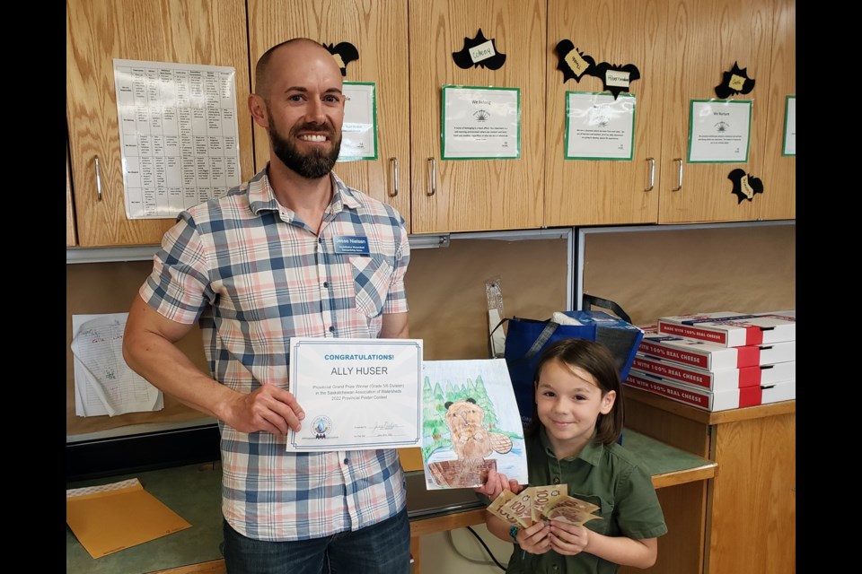 Ally Huser, age 9, in Grade 4 at Davison School in Melville is presented her award by AWSA manager, Jesse Nielsen.