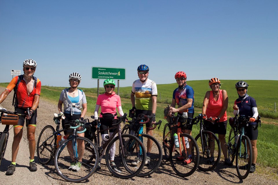 Riders of the 2025 Great Annual Saskatchewan Pedal were photographed at the Canada (Saskatchewan) / United States (North Dakota) border crossing of the Port of Oungre. From left, they are: Mike Renouf, Gay Renouf, Maya Moore, Noel Roche, Terry Craig, Aldona Torgunrud and Juan Yan.