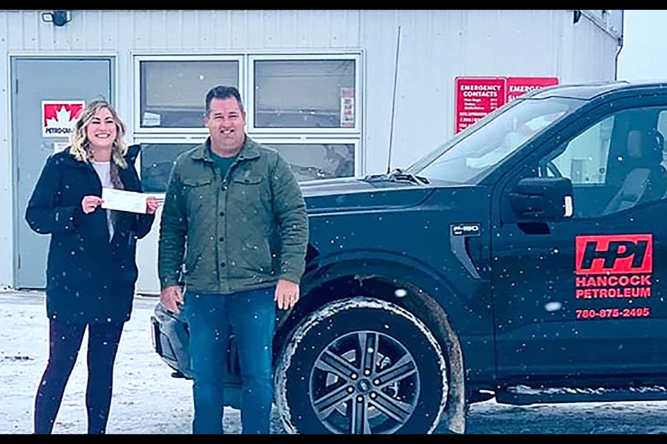 Jason Hancock of Hancock Petroleum Ltd. presents a cheque for $500 to Hayley Yuill, Maidstone Guiding leader.