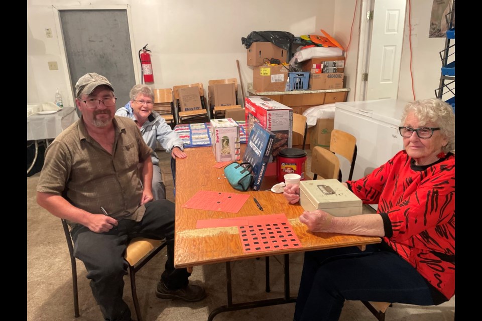 Ranger community people sitting at the door selling supper tickets and draws before the fireworks July 1.