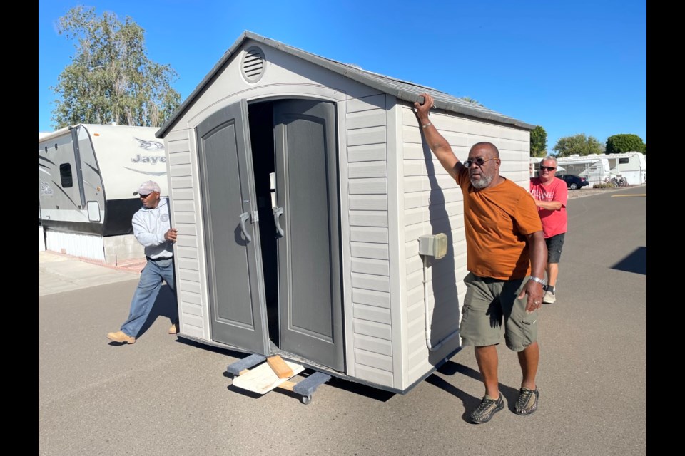 Nothing like manpower moving a fair-sized tool shed on a private street in a trailer park. This one was to get replaced by a smaller unit which would take only four men rather than seven. | 