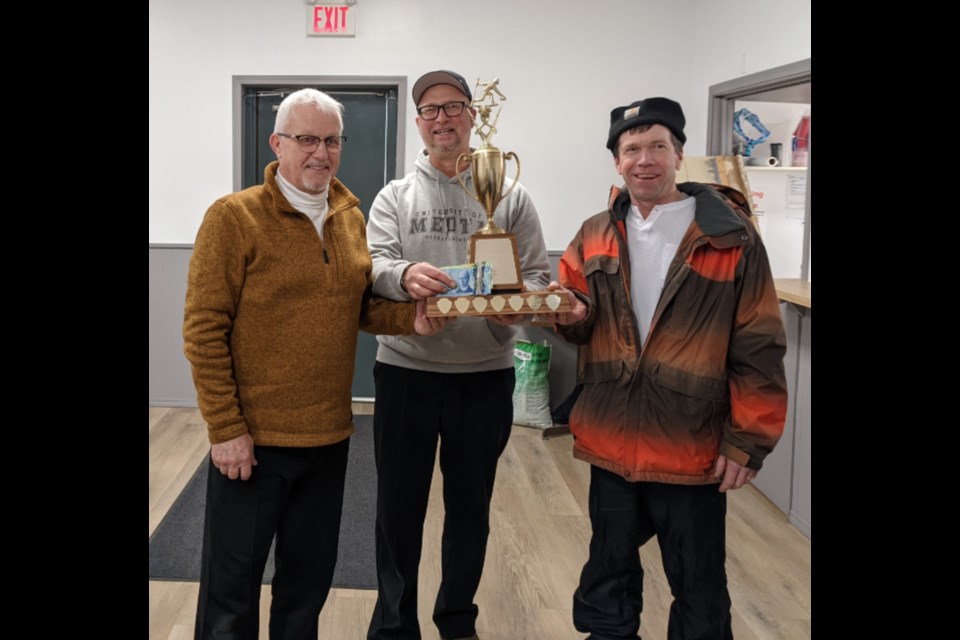 Steve Ackerman and Duane Clarke accepting their trophy from Pat Mohr as Pool A winners of the Meota Curling Club's Broom For 2 Sturling Spiel. 