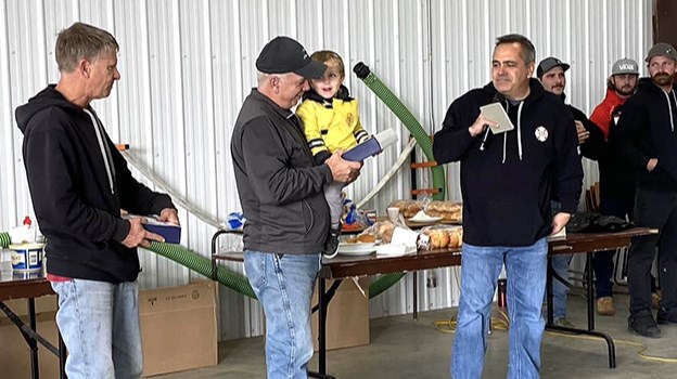 Retired firefighters Terry Tait and Ed Cadrin receive presentations from Chief Dean Menssa at the Meota and District Volunteer Fire Department barbecue Oct. 29.