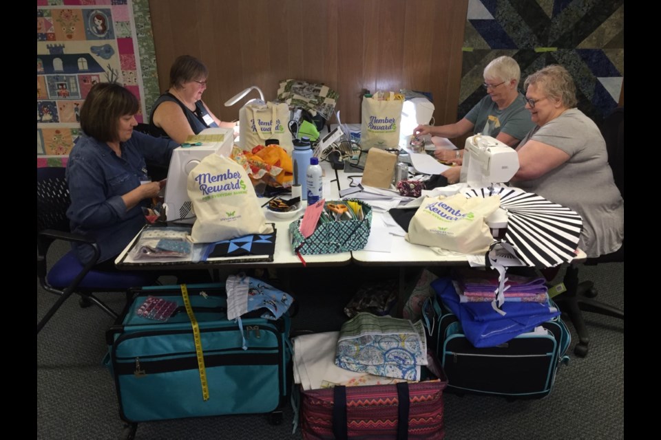 Some of the quilters at the retreat in Radisson busily sewing on their quilts. 